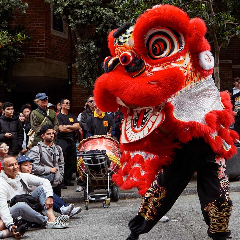 Lion dance performance in San Francisco Chinatown with audience watching during filming of The Mo Lum documentary.